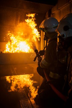 Yangın söndürücü ve su kullanan itfaiyeci, acil bir durumda yangın aleviyle mücadele eder. Tehlike anında bütün itfaiyeciler güvenlik için itfaiyeci kıyafeti giyer..