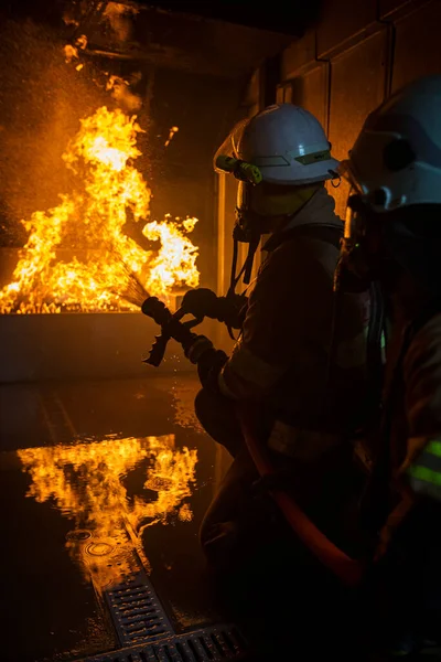 Feuerwehrmann Mit Wasser Und Feuerlöscher Bei Der Bekämpfung Der Flammen — Stockfoto