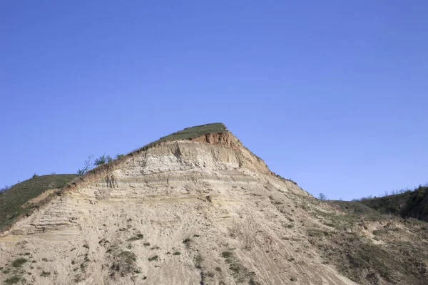 View of a clay precipice. The background is the blue sky.