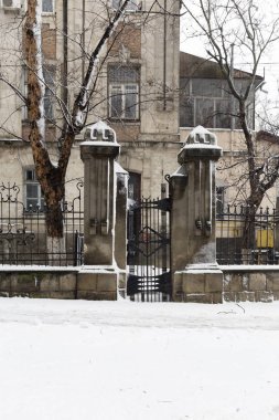 Taş çit dikenli dikey görüntü üzerinde yer alır. Çit ve bina Columna sokakta, Chisinau yer.