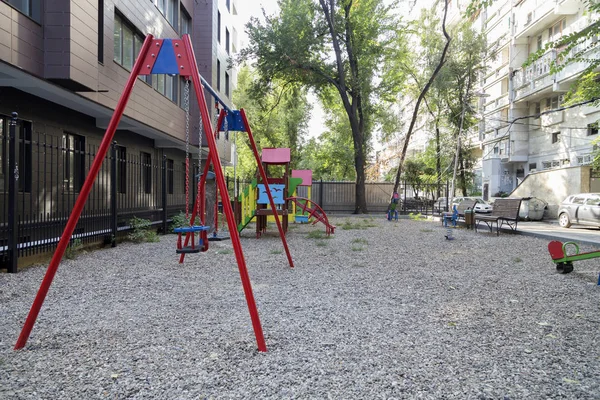 Modern courtyard in the new housing building. Colourful playground for children in public housing block.