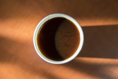 Üstten görünüm bir kağıt fincan sade kahve. Bu bir ahşap yüzeye bulunur.