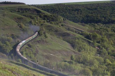 Tren yeşil tepelerin arasında gidiyor. Moldova güzel kez bakıldı.