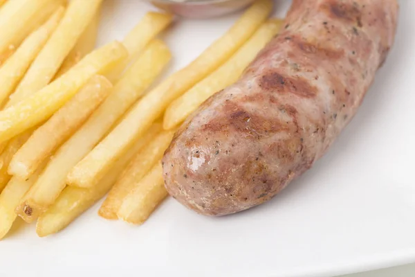Part of breakfast with sausage and french fries. Close-up.