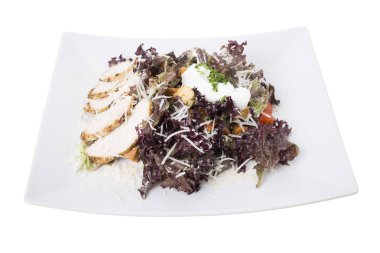 Sezar salatası ile beyaz tabakta tavuk. Beyaz bir arka planda izole. Yakın çekim.