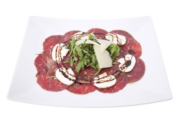 Carpaccio eti parmesan peynir ve roka ile. Beyaz bir arka planda izole. Yakın çekim.