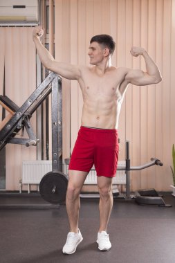 Genç adam kasları ile Halter salonunda esneme. Yakın çekim.