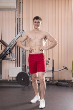 Genç adam kasları ile Halter salonunda esneme. Yakın çekim.