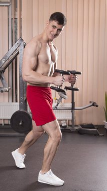Genç adam kasları ile Halter salonunda esneme. Yakın çekim.