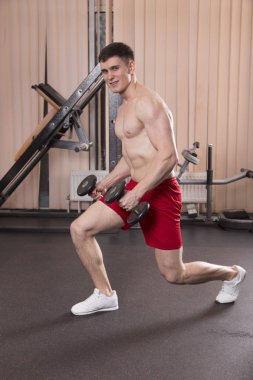 Genç adam kasları ile Halter salonunda esneme. Yakın çekim.