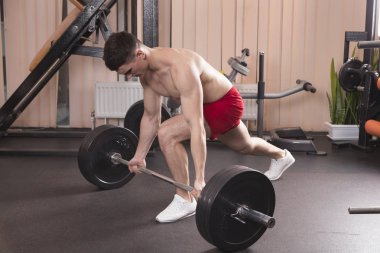 Genç adam kasları ile Halter salonunda esneme. Yakın çekim.