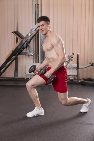 Genç adam kasları ile Halter salonunda esneme. Yakın çekim.