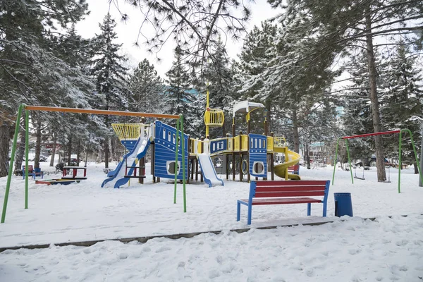 Parque infantil colorido é coberto de neve no inverno . — Fotografia de Stock