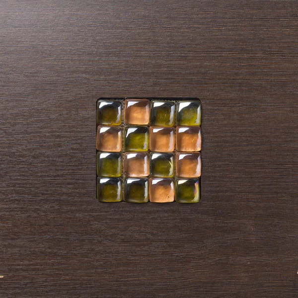 Cubes en verre multicolores sur une surface en bois . — Photo