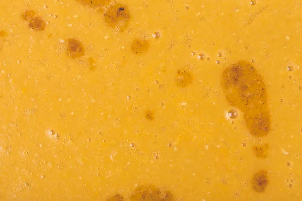 Pomarańczowa zupa warzywna z dużymi plamami tłuszczowymi. — Zdjęcie stockowe
