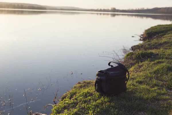 Bak nero del fotografo su una riva del lago . — Foto Stock