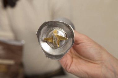 Bir el özel bir bıçakla mikser başlığı tutar.