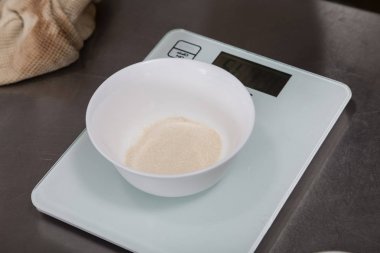 Bir bardak agar bir mutfak ölçeği üzerinde tartılır.