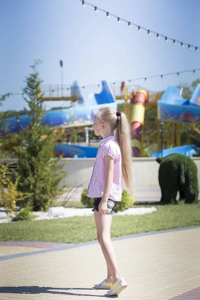 Linda niña hermosa en un parque infantil . — Foto de Stock