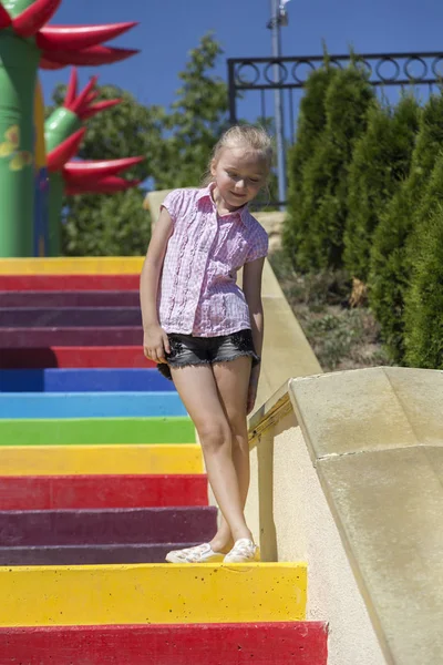 Linda niña hermosa en un parque infantil . — Foto de Stock