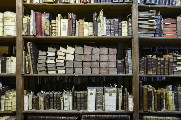 stock image Ancient books on old wooden bookshelf with tags and old covers in university library