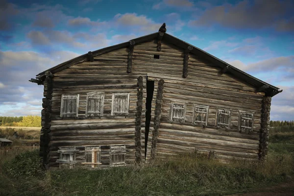 Parlak bulutlu gökyüzü ve sonbahar arka plan sahne karşı güneşli bir gün Rus köyünde ahşap günlük evin ön görünümü, ev kırık.