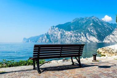Riva del Garda, İtalya yakınlarındaki Torbole'de bir bankı olan Gardasee (Garda Gölü) manzarası