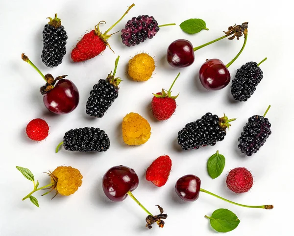 Fruit collection on a white background with mulberry, red raspberries, raspberries, blackberries, cherries, mint leaves