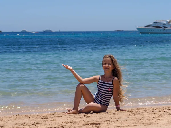 海の砂浜で風に流れる長い髪を持つヨーロッパの出現の9歳の女の子の肖像画 — ストック写真