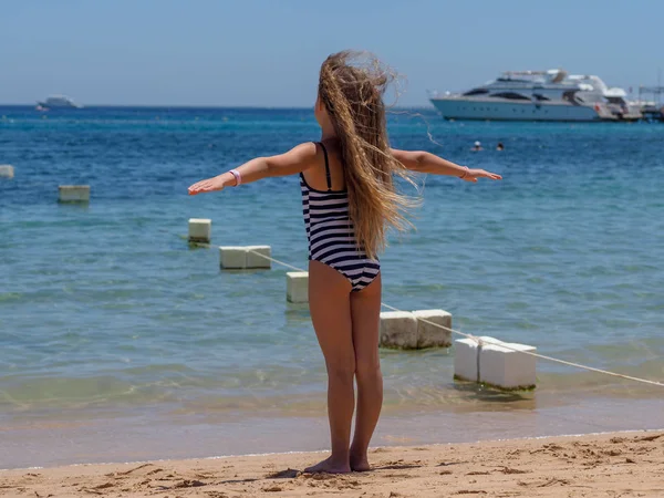 bir deniz kumlu plajda rüzgarda atarak akan uzun saçları ile Avrupa görünüm 9 yıllık bir kız portresi