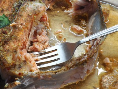 Metal çatallı, şeffaf camdan yapılmış somon bifteği.