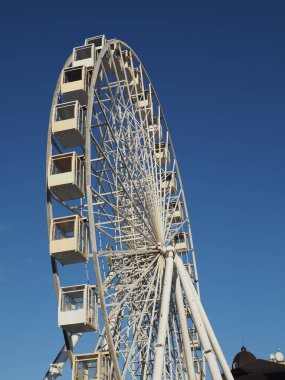 Mavi gökyüzünün arka planında insanlar olmadan dönme dolap