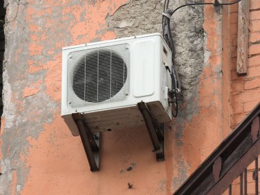 Evin ön cephesinde eski bir havalandırma ünitesi var.