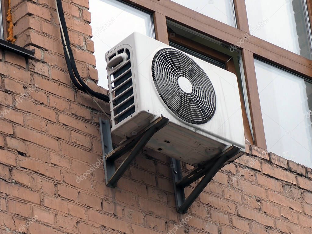 old outdoor air conditioning unit on the facade of the house