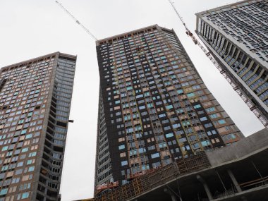 Gri gökyüzünün arka planında bir gökdelenin parıltısı