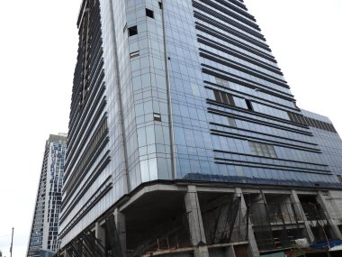 Gri gökyüzünün arka planında bir gökdelenin parıltısı