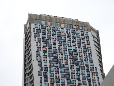 Gri gökyüzünün arka planında bir gökdelenin parıltısı