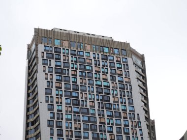 Gri gökyüzünün arka planında bir gökdelenin parıltısı