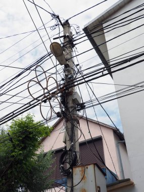 Kasaba elektrik kabloları ve kablolarıyla dolu aşırı yüklenmiş bir direk.