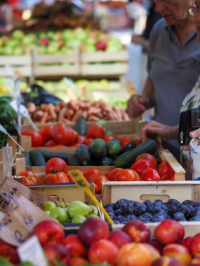 Olgun çiftlik sebzeleri ve meyveler köy panayırının tezgahındaki tahta kutularda.