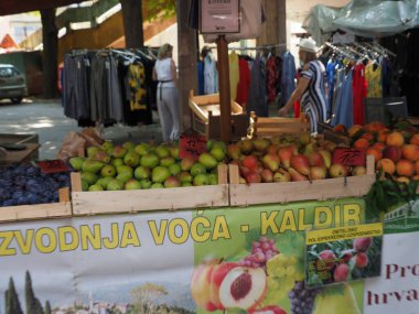 Hırvatistan, Medulin, 24 Temmuz 2019: Köy panayırının tezgahındaki ahşap kutularda olgun çiftlik armutları ve şeftalileri