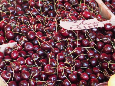 Hırvatistan, Medulin, 24 Temmuz 2019: Köy panayırının tezgahındaki ahşap kutularda olgun çiftlik kirazları