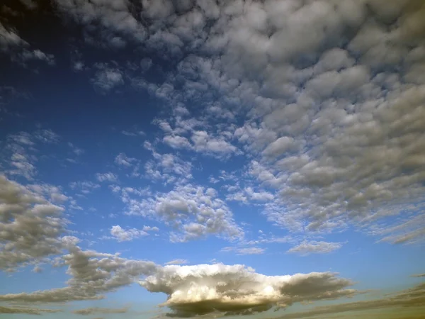 white and gray clouds in the blue sky illuminated by the sun