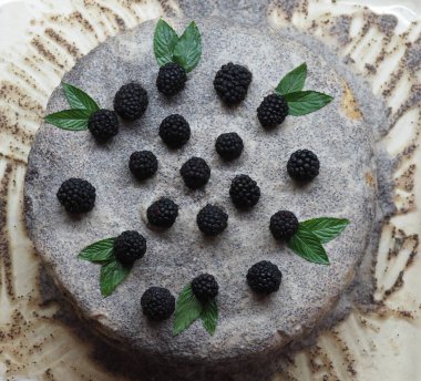 Ev yapımı haşhaş tohumu ile doldurulmuş un ve böğürtlenlerle süslenmiş kek.