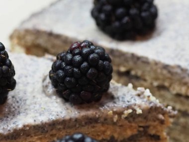 Ev yapımı haşhaş tohumu ile doldurulmuş un ve böğürtlenlerle süslenmiş kek.