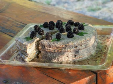 Ev yapımı haşhaş tohumu ile doldurulmuş un ve böğürtlenlerle süslenmiş kek.