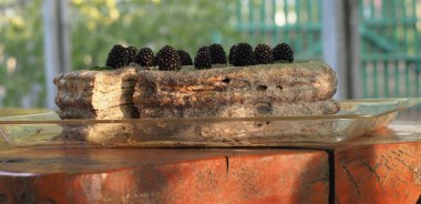 Ev yapımı haşhaş tohumu ile doldurulmuş un ve böğürtlenlerle süslenmiş kek.