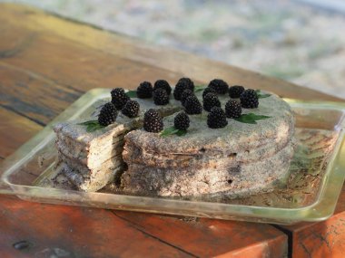 Ev yapımı haşhaş tohumu ile doldurulmuş un ve böğürtlenlerle süslenmiş kek.