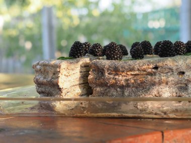 Ev yapımı haşhaş tohumu ile doldurulmuş un ve böğürtlenlerle süslenmiş kek.