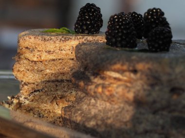 Ev yapımı haşhaş tohumu ile doldurulmuş un ve böğürtlenlerle süslenmiş kek.